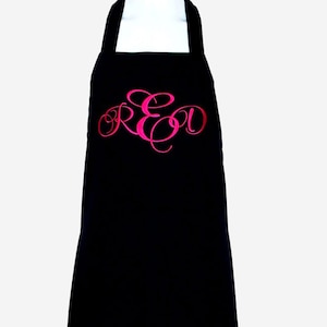 May include: A black apron with a pink embroidered monogram "RED" on the front.