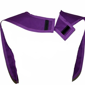 May include: Purple fabric neck wrap with two adjustable straps and velcro closures.