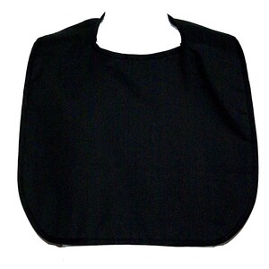 May include: A solid black bib with a rounded bottom and a curved neckline. The bib is made of a soft, textured fabric and is designed to protect clothing from spills and stains. The shape is a simple, functional design.