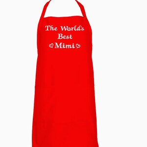 May include: Red kitchen apron with white embroidered text that reads "The World's Best Mimi" with a heart symbol on either side of the word Mimi.