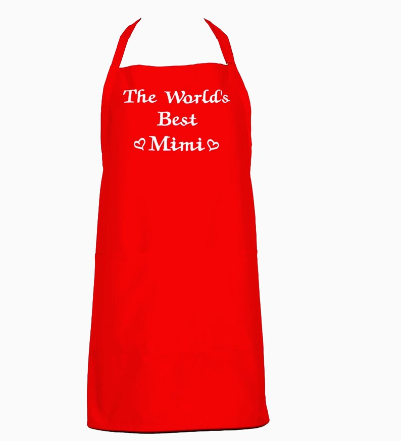 May include: Red kitchen apron with white embroidered text that reads "The World's Best Mimi" with a heart symbol on either side of the word Mimi.