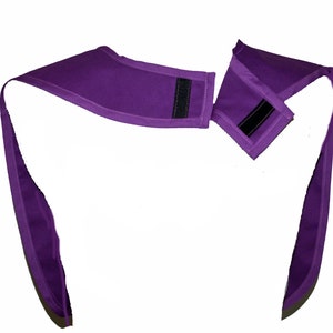 May include: Purple fabric neck wrap with two adjustable straps and velcro closures.
