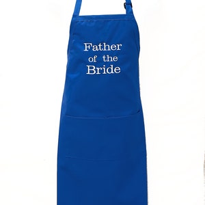 May include: Royal blue apron with a large pocket and adjustable straps. The apron is embroidered with the text "Father of the Bride" in white.
