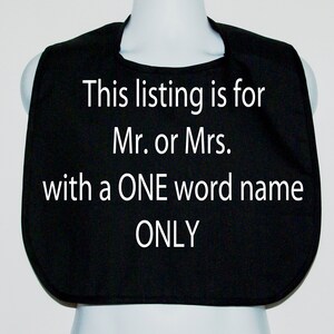 May include: Black baby bib with white text that reads: "This listing is for Mr. or Mrs. with a ONE word name ONLY."