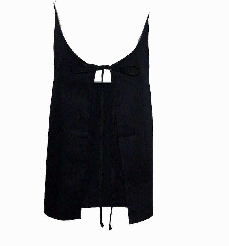 May include: A black sleeveless top with a tie at the back. The top has a scoop neck and a loose fit.
