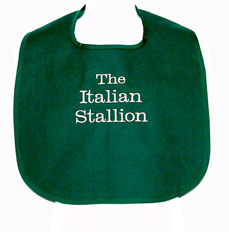 May include: A green bib with white embroidery that reads "The Italian Stallion".