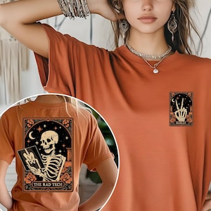 A Halloween-themed Radiology Tech shirt featuring a skeleton holding an X-ray plate under a crescent moon with floral details. The design includes “THE RAD TECH” text at the bottom, printed in vintage orange tones — a perfect spooky yet professional gift for radiology or X-ray technicians.