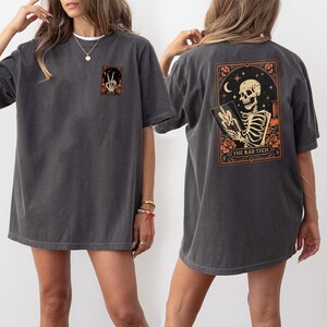Close-up of the skeleton radiology shirt showing intricate Halloween artwork with stars, flowers, and a glowing skeleton hand forming a peace sign. Ideal for X-ray techs or radiologists who want to celebrate spooky season while showing pride in their profession.