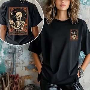 Halloween-themed radiology tech apparel showing a skeleton taking an X-ray in a celestial background with stars and flowers. Printed on soft cotton fabric, this shirt is both comfortable and fun — a perfect blend of spooky style and medical pride.