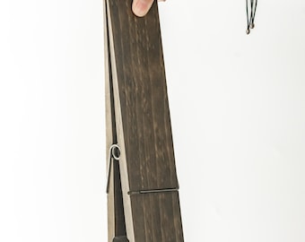 May include: A dark brown wooden clothespin with a metal spring.