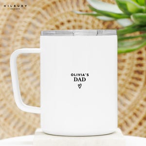 May include: White travel mug with a silver lid and a white handle. The mug features the text "OLIVIA'S DAD" with a heart symbol below. The Hilbury Designs logo is in the upper left corner.
