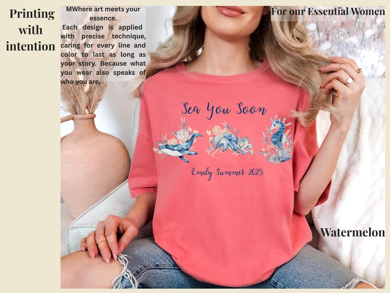 May include: A coral-colored t-shirt featuring a blue graphic of a whale, octopus, and seahorse surrounded by flowers. The text reads Sea You Soon and Emily Summer 2025. The shirt is worn with blue denim jeans. The design is printed with intention.