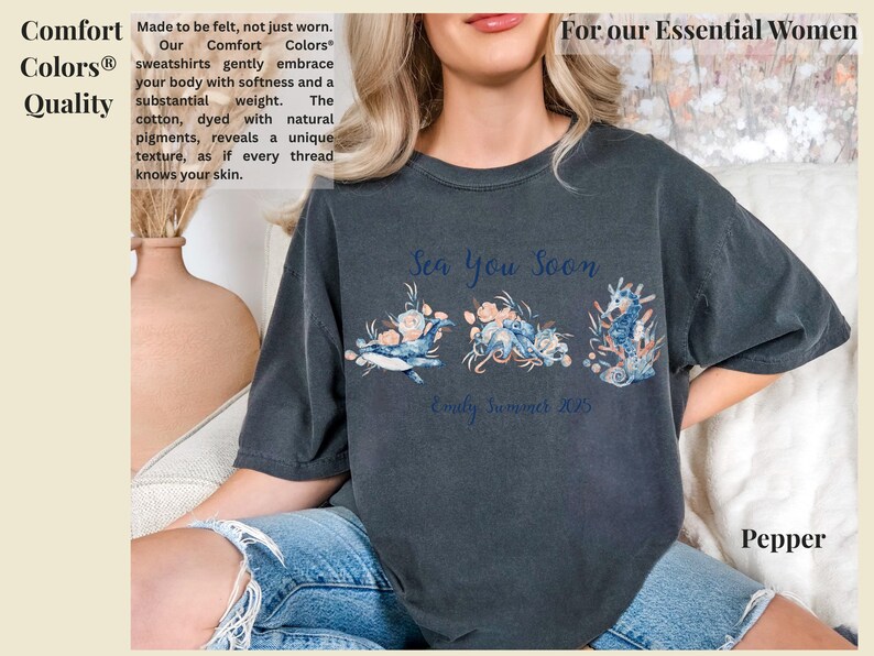 May include: A charcoal gray short-sleeve t-shirt featuring a graphic print of a whale, an octopus, and a seahorse adorned with floral elements. The text "Sea You Soon" and "Emily Summer 2025" is printed in blue script above and below the sea creatures.