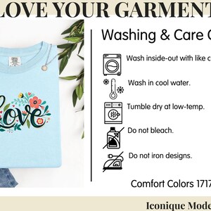 May include: A light blue t-shirt featuring the word Love in black script surrounded by colorful floral illustrations. The image includes a Washing & Care Guide with icons and text: Wash inside-out, wash in cool water, tumble dry low, no bleach, no iron.