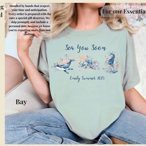 May include: A light green t-shirt featuring a graphic print of a whale, an octopus, and a seahorse surrounded by coral and flowers. The text "Sea You Soon" is printed above the marine life, and "Emily Summer 2025" is printed below the illustrations.