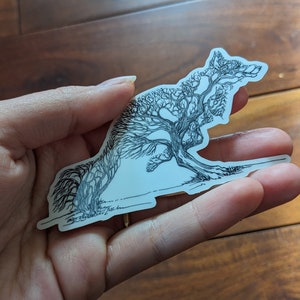 May include: A black and white line drawing of a tree shaped like a fox. The tree is stylized with many branches and leaves.