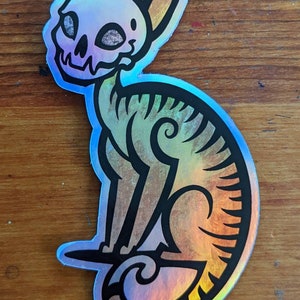 Holo Skull Kitty - die cut holo all weather vinyl sticker of a cat with a skull head cartoon cute brown white dark creepy spooky