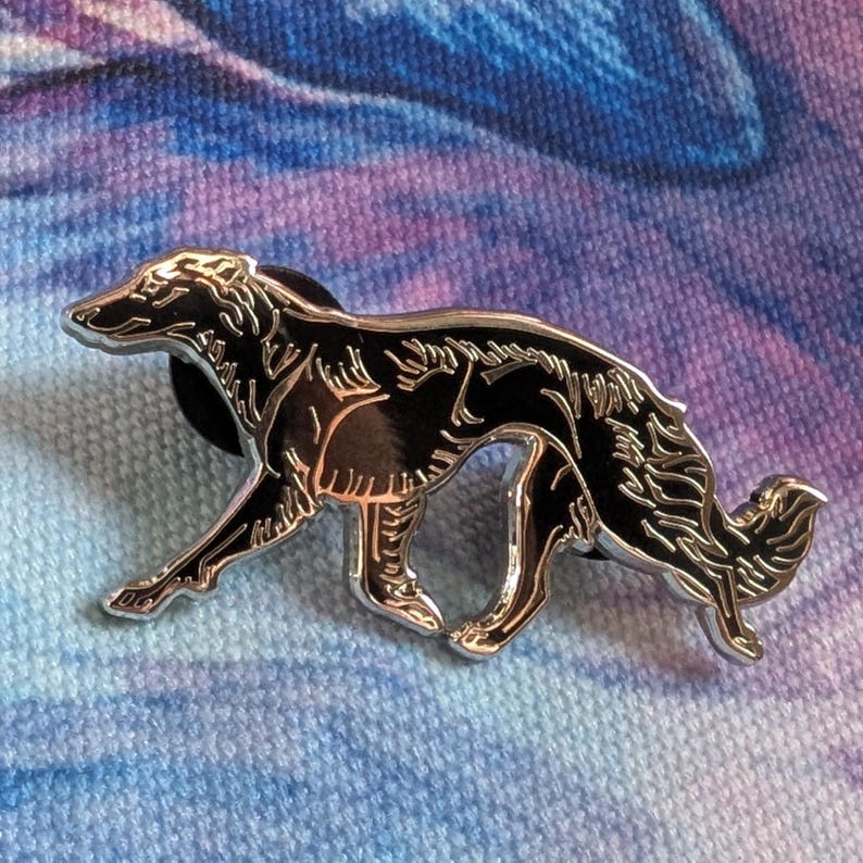 K&ouml;nnte beinhalten: Ein silberfarbener Metall-Pin in Form eines Borzoi-Hundes. Der Pin hat eine schwarze Emaille-F&uuml;llung und ist vor einem blau-violetten Hintergrund platziert. Der Hund wird in einer Laufpose mit detaillierten Merkmalen dargestellt.