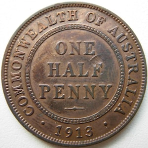 Könnte beinhalten: Eine kupferfarbene australische One Half Penny Münze von 1913. Der Münzrand trägt die Inschrift "COMMONWEALTH OF AUSTRALIA", während "ONE HALF PENNY" im Zentrum steht. Die Jahreszahl "1913" ist unten zu sehen.
