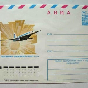 Pode incluir: Um envelope de correio aéreo branco com uma borda listrada em vermelho e azul. Exibe um gráfico do avião de passageiros supersônico Tu-144 voando sobre um sol estilizado. O texto inclui "А В И А", "СВЕРХЗВУКОВОЙ ПАССАЖИРСКИЙ САМОЛЕТ ТУ-144", "Куда", "Кому" e linhas de endereço.