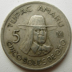 Può includere: Una moneta d'argento con il ritratto di Tupac Amaru con un cappello. La moneta reca l'iscrizione "TUPAC AMARU" in alto e "CINCO SOLES DE ORO" in basso. Un grande "5" è visibile sul lato sinistro.