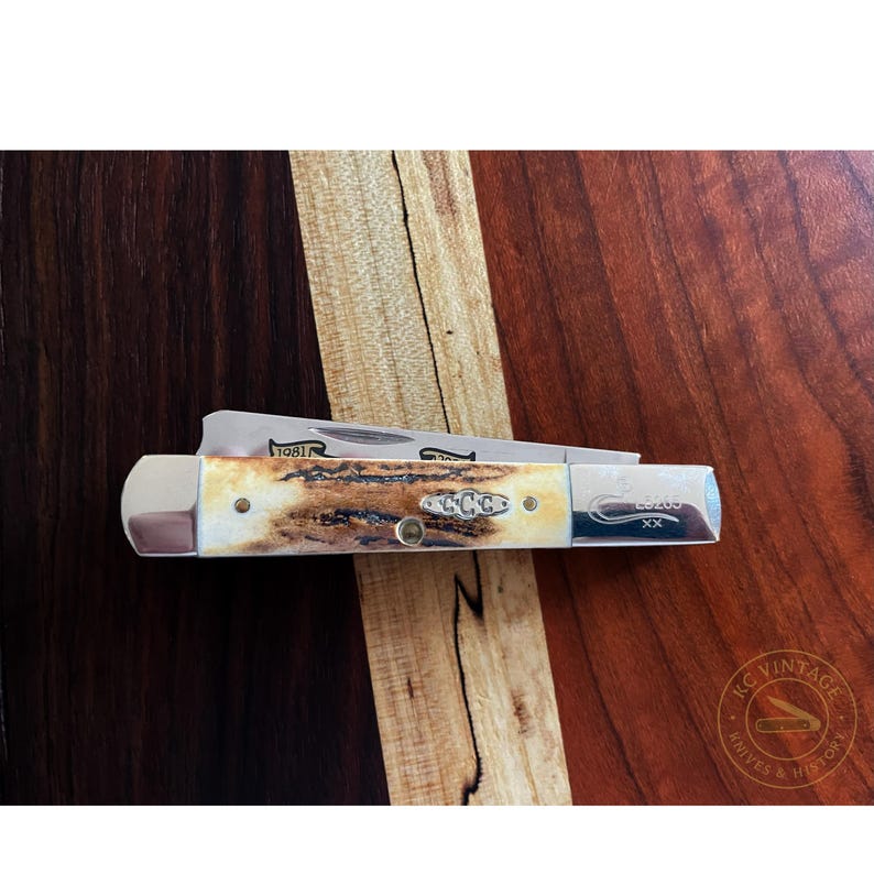 Puede incluir: Una navaja de bolsillo vintage con una hoja de acero inoxidable y un mango con un patr&oacute;n crema y marr&oacute;n. La navaja tiene el texto "1981" y "L9200" grabado en la hoja y el mango. La navaja se muestra sobre una superficie de madera.