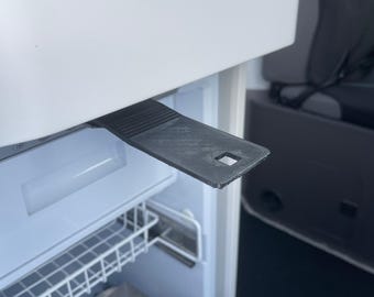 May include: A white refrigerator with a black plastic handle. The refrigerator has a wire shelf and a metal drawer.