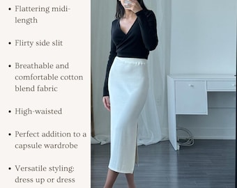 Puede incluir: Una falda midi blanca con una abertura lateral y cintura alta. La falda está hecha de una tela cómoda de mezcla de algodón y tiene una cintura elástica que estiliza. La falda se muestra en una modelo que lleva un top negro de manga larga y tacones negros.