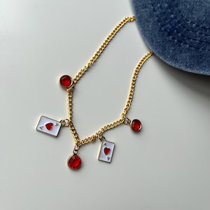 Collar de as de corazones dorado y piedras rojas: bisutería romántica y divertida