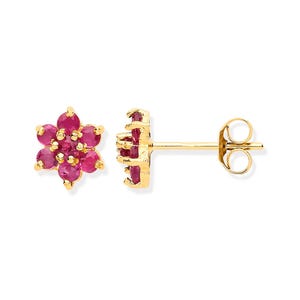 May include: A pair of gold stud earrings with a flower design. Each earring features a cluster of bright red gemstones set in a gold frame. The earrings are presented against a white backdrop.