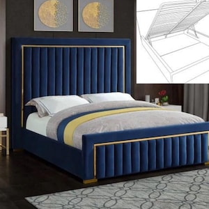 May include: A navy blue upholstered bed with gold trim. The headboard and footboard have vertical channel tufting. The bed is made up with white pillows, a grey and yellow comforter, and a patterned rug.