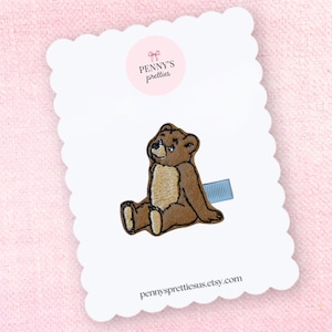 May include: A white ceramic mug with a black handle and the text "But First, Coffee" in a bold, black font. The mug is set against a neutral background, highlighting its simple design.