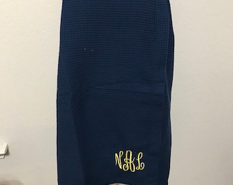 May include: A navy blue waffle weave bath wrap with a yellow embroidered monogram "N&L".