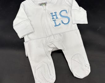 Puede incluir: Mono blanco para bebé con cremallera completa y pies. El mono presenta las iniciales bordadas "HS" y "LS" en azul claro en el pecho. La prenda está hecha de un material suave y cómodo.