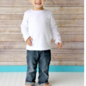 May include: A white long-sleeved t-shirt on a young boy. The shirt has a crew neck and is made of a soft, comfortable fabric.