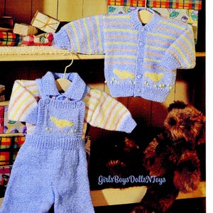 May include: A light blue knitted baby outfit set, including a cardigan and overalls. The cardigan has yellow and orange stripes and bird-shaped pockets. The overalls have a yellow bird design on the bib. The text "GirlsBoysDollsNToys" is visible.