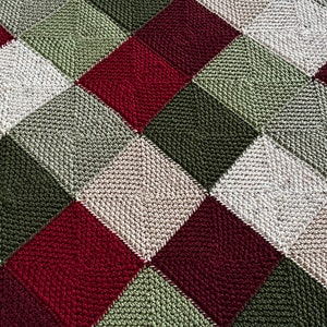 May include: A knitted blanket with a checkered pattern in shades of beige, green, and burgundy.