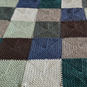 May include: A crocheted blanket with squares in shades of green, brown, and blue.