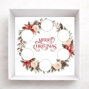 May include: A square white box containing a card with a Christmas wreath illustration featuring red poinsettias, white roses, pine needles, holly berries, and a pinecone. The text Merry Christmas is centred, surrounded by six empty circular cutouts.