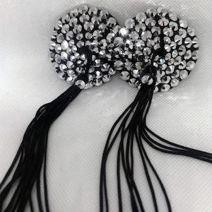 May include: Two silver rhinestone pasties with black tassel fringe.