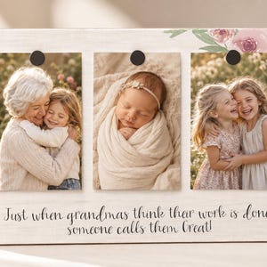 May include: A wooden photo frame with three rectangular openings, each holding a different photograph. The frame is decorated with floral accents and the text "Just when grandmas think their work is done, someone calls them Great!"