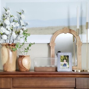 a wooden dresser topped with vases filled with flowers
