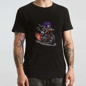 May include: Black t-shirt featuring a graphic of a purple-haired character riding a red motorcycle with flames. The character wears a black cape and has a sinister expression. The motorcycle has a detailed design.