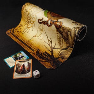 May include: A rolled-up, tan play mat with a detailed illustration of a figure holding a hook, alongside two game cards and a six-sided die. The mat has a map-like design.