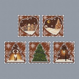 May include: A collection of five cross-stitch designs featuring winter scenes. Each design is framed with a brown border and white snowflakes. The scenes include a town, a Christmas tree, a deer, a full moon, and a street lamp.