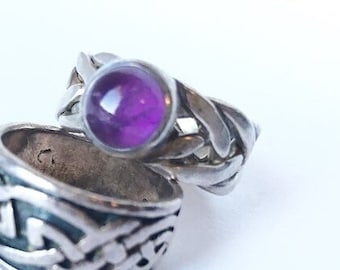 May include: Two silver rings with a Celtic knot design. The top ring has a purple gemstone.