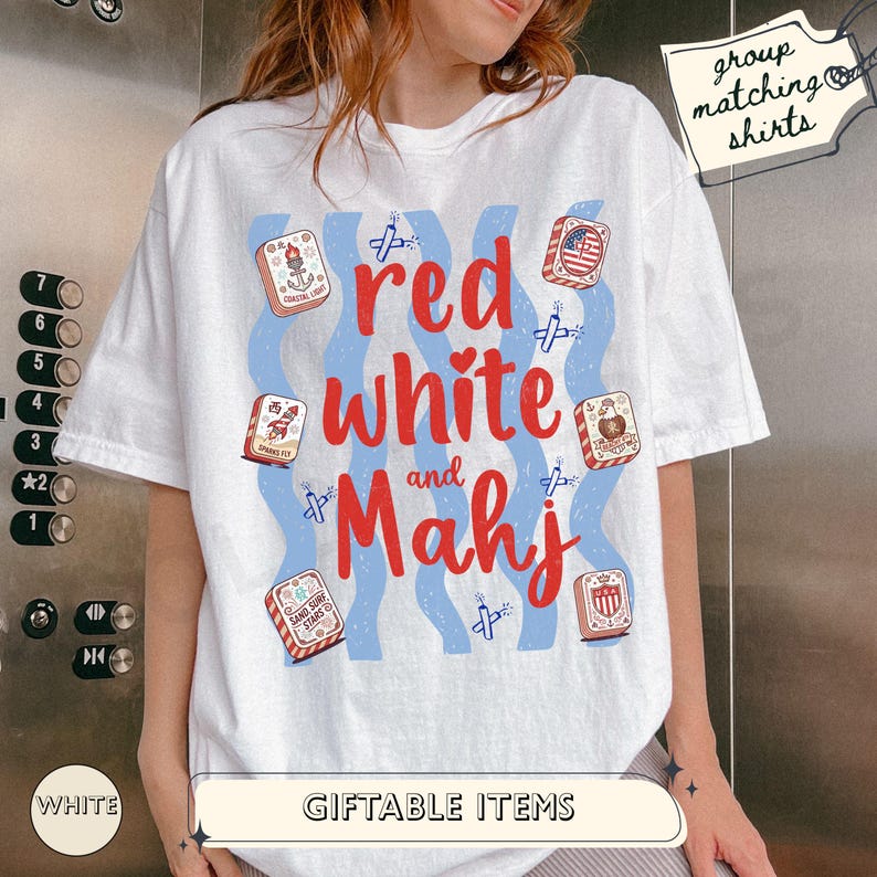 May include: A white short-sleeve t-shirt featuring the red text "red white and Mahj" surrounded by blue wavy lines, small firecracker illustrations, and six mahjong tiles with patriotic designs. A tag in the corner reads "group matching shirts".