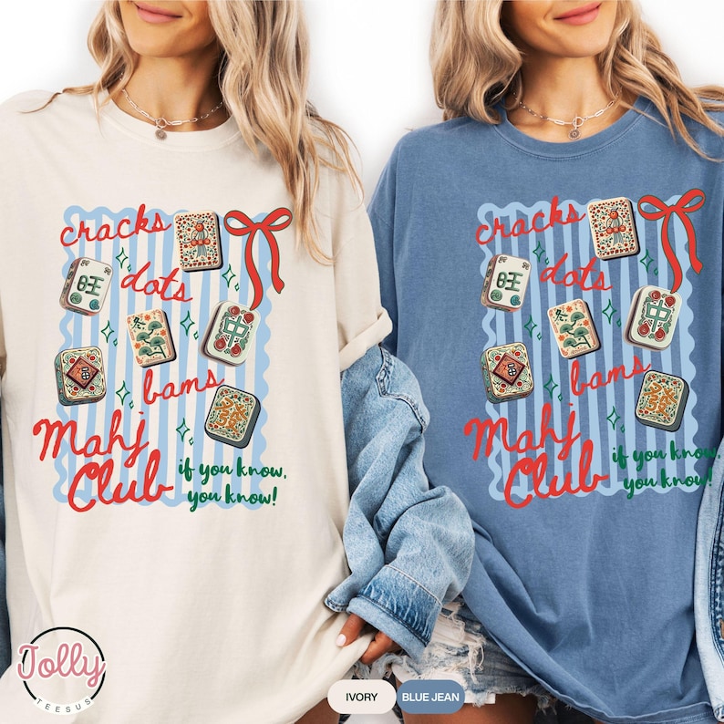 May include: Two long-sleeved t-shirts, one ivory and one blue jean, featuring a graphic design. The design includes the words "cracks, dots, bams, Mahj Club" with decorative elements and the phrase "if you know, you know!"
