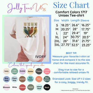 May include: An ivory t-shirt featuring a graphic of four birds and four mahjong tiles. The image includes a size chart with measurements in inches for sizes S through 3XL, and a color palette showing various available shirt colors.