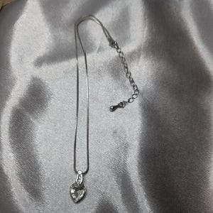Collana vintage con ciondolo a forma di cuore color argento.